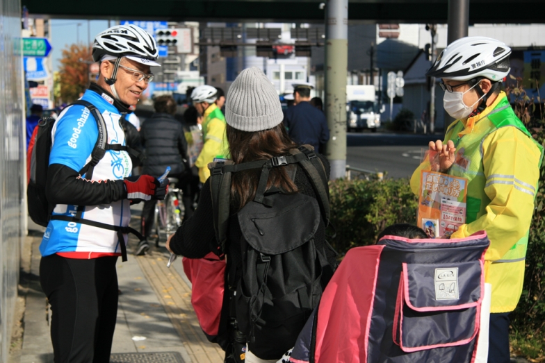 梅島交差点で自転車利用者にマナーアップを呼びかけるチラシを配布した