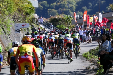 7周目へ入るメイン集団。多くのファンの声援を受けて厳しい坂を上る　©JBCF 一般社団法人 全日本実業団自転車競技連盟
